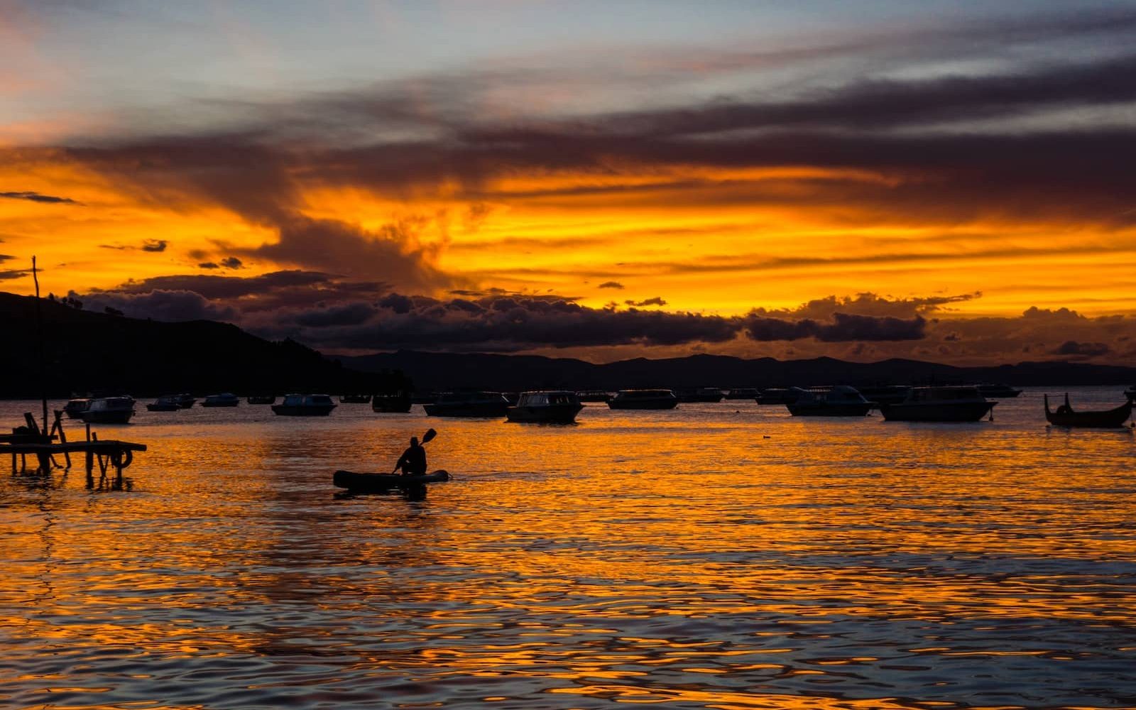 silhouette of person riding on boat during golden hour